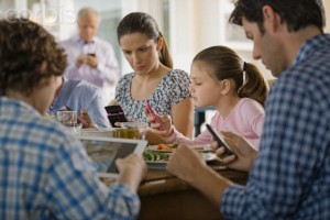 Family including kids (8-9) texting at dinner table